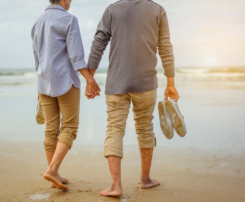 two people walking on the beach