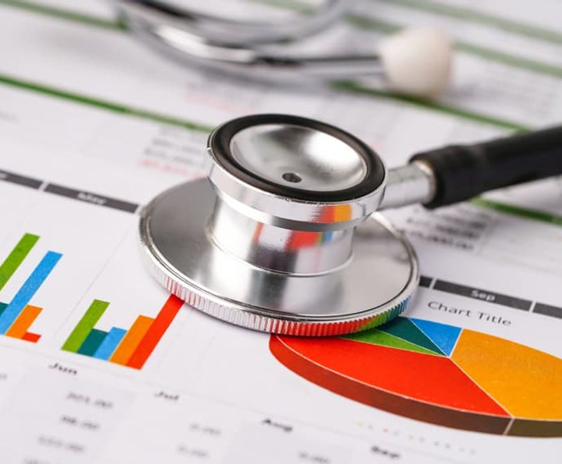 stethescope on top of papers with charts