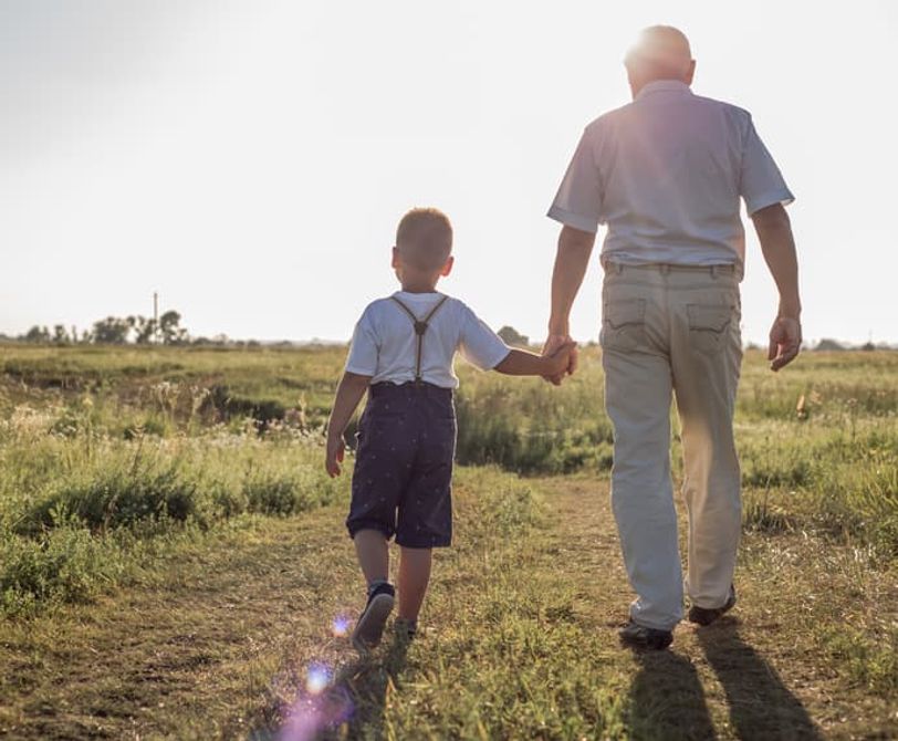 man and child walking on a gravel path